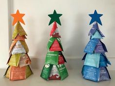 three small christmas trees made out of different types of paper