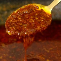 a spoon full of chili sauce being stirred