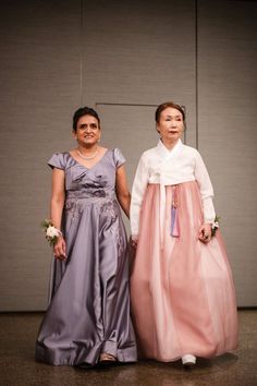 two women in dresses standing next to each other