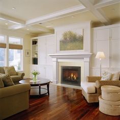 a living room filled with furniture and a fire place in the middle of a room