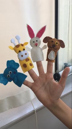 hand with five finger puppets made to look like animals