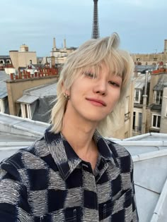 a woman with blonde hair standing in front of the eiffel tower