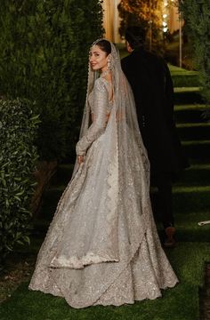 the bride and groom are walking down the aisle at night in their wedding gowns