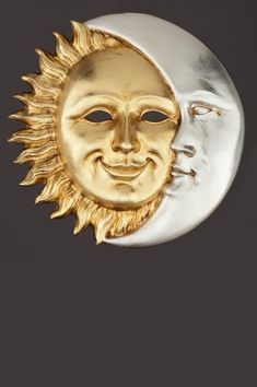 a gold and silver sun and moon brooch with the face of a smiling man