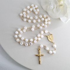 This Personalized Rosary, is ideal as a Baptism gift for a little girl or baby boy or as a gift for a special occasion. It is expertly handcrafted in a traditional style with a contemporary twist utilizing genuine Mother of pearl stone and gold-plated brass wire, which not only gives a touch of nature but also tenderness. The letter beads on the Rosary are also handmade from genuine mother of pearl, and the length is perfect to worn as a dainty Rosary necklace for women. *MATCHING ROSARY BRACELE White Spiritual Cross Jewelry And Charms, Handmade Rosary With Round Beads For Baptism, White Jewelry For Confirmation On Mother's Day, Handmade Adjustable Rosary For First Communion, White Necklace For First Communion And Mother's Day, Spiritual 8mm Beads Rosary For Baptism, Personalized White Cross Jewelry, Elegant Round Beads Rosary For First Communion, Rosary Bracelet With 8mm Round Beads For Baptism