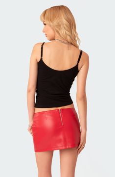 a woman wearing a red leather skirt and black tank top with her back to the camera