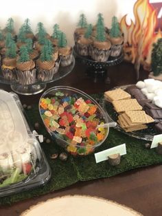 a table topped with lots of desserts and cupcakes on top of it