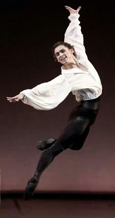 a man in white shirt and black pants doing a trick on the dancefloss