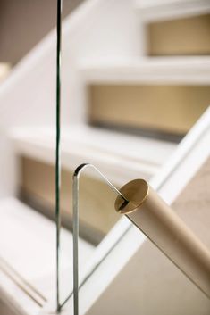 a close up view of a handrail on a stair case with glass railings