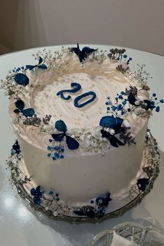 a white cake with blue decorations and the number 50 on it sitting on a table