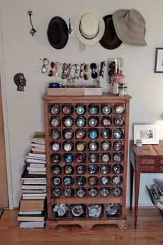 a wooden shelf filled with lots of hats on top of a hard wood floor next to a wall