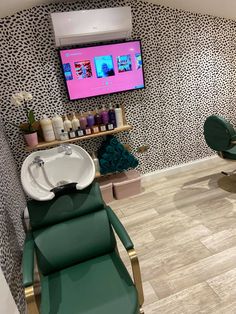 a salon with green chairs and a flat screen tv on it's wall above a sink