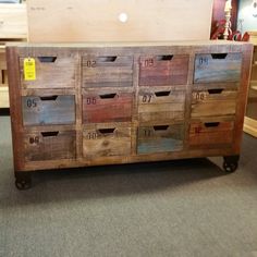 an old wooden cabinet with drawers and numbers on the doors is displayed in a store