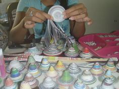 a woman sitting at a table with lots of crafting supplies on top of it