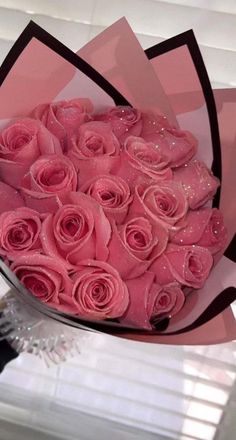 a bouquet of pink roses sitting on top of a window sill