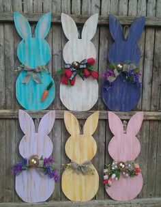 wooden easter bunnies are decorated with flowers and carrots for the side of a fence