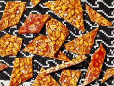 several pieces of pizza with nuts and sauce on a black and white tablecloth background