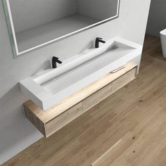 two white sinks sitting on top of a wooden floor next to a large mirror above them