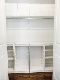 an empty walk in closet with white shelving and wood flooring on the side