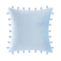 a white pillow with blue pom - poms on the front and back of it