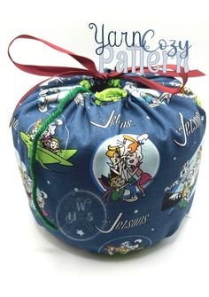 a blue pouch with cartoon characters on it and a red ribbon tied around the bottom