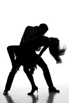 two people in silhouette dancing on a dance floor