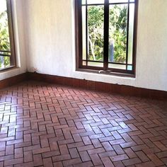 an empty room with two windows and tiled floor