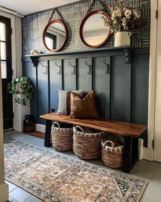 a bench with two mirrors above it and some baskets on the floor next to it