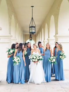 a group of bridesmaids in blue dresses standing together