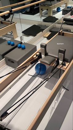 an exercise room with blue balls on the floor and mirrors in the wall above it