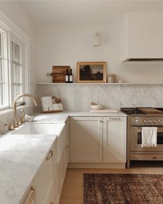 a kitchen with marble counter tops and white cabinets, along with a rug on the floor