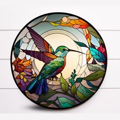 a stained glass hummingbird sitting on a branch