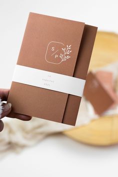 a person holding up a brown and white book with the word spring written on it