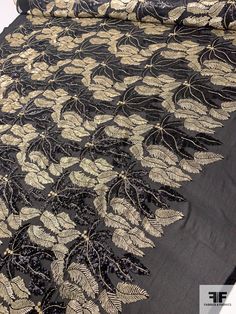 a black and gold lace with leaves on it