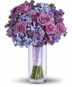 a vase filled with purple and lavender flowers