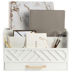 a white desk organizer filled with office supplies and notebooks on top of each other