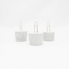 three white concrete planters sitting on top of each other