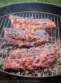 two steaks are cooking on the grill