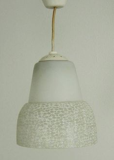 a white light hanging from a ceiling with a brown cord attached to the top of it