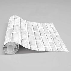 a roll of white marble tile sitting on top of a gray floor