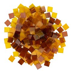 a pile of yellow and brown colored glass tiles on a white background with clippings