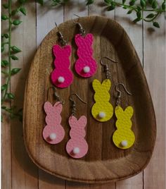 four pairs of bunny earring on a wooden tray