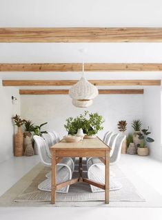 a dining room with white walls and wooden beams