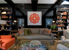 a woman standing next to a living room filled with furniture and a phone booth on the wall