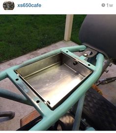 a metal tray sitting on the back of a motorcycle