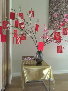 a vase filled with pink flowers sitting on top of a table next to a wall