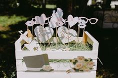 a white box filled with lots of cut out hearts and flowers on top of grass