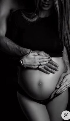 black and white photograph of a woman's stomach with her hands on the belly