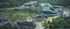 an aerial view of a building in the middle of a green area with trees around it