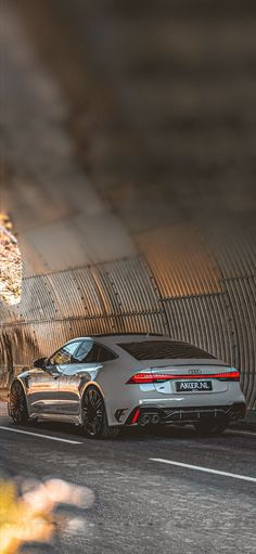 a silver sports car driving through a tunnel